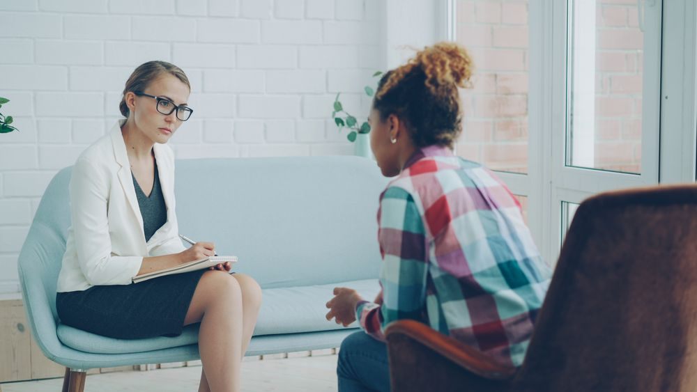 A counselor listening attentively to a patient during a behavioral health session